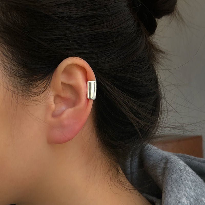 Minimalist sterling silver ear cuff with a sleek cylinder design for a modern and edgy look.