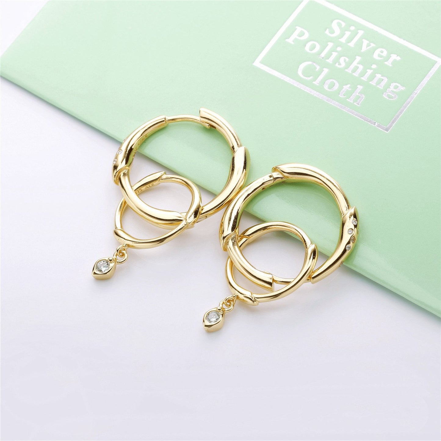 Gold hoop earrings with an interchangeable diamond charm for a versatile and stylish look.