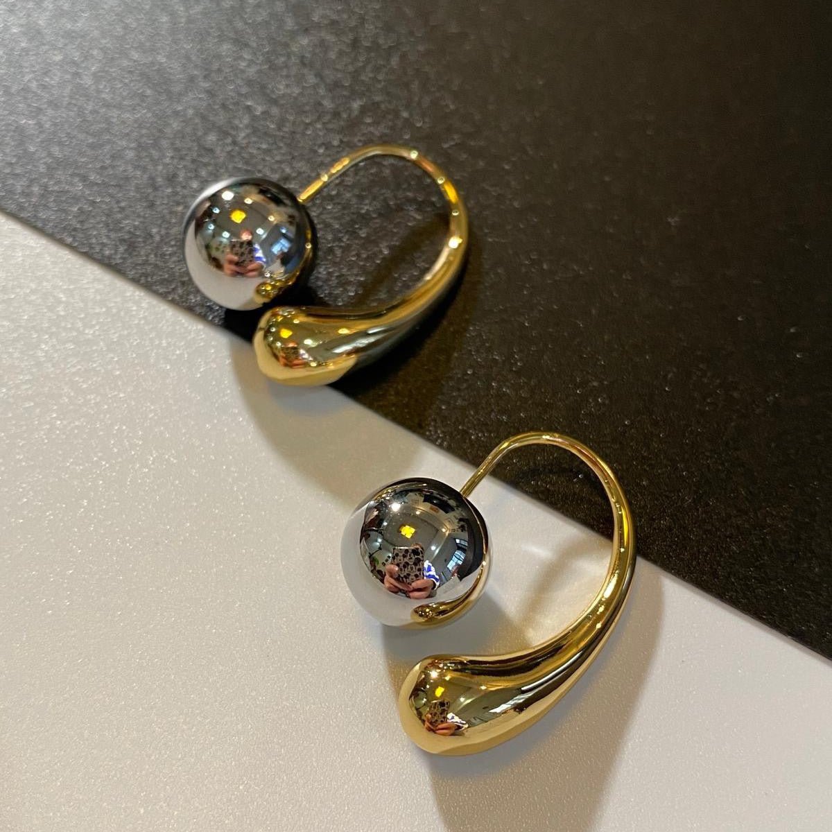 Two-toned dangle earrings in gold and silver with a bold mixed-metal design for a statement look.