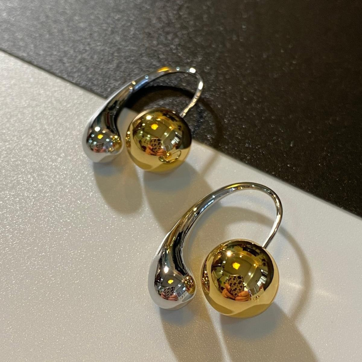 Two-toned hoop earrings in gold and silver with a bold mixed-metal design for a statement look.