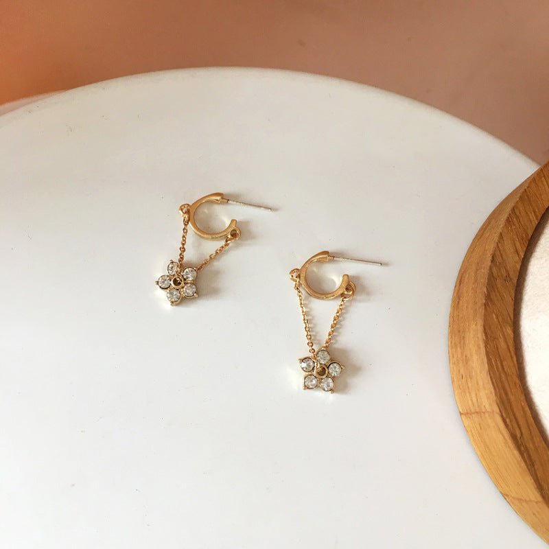 Gold hoop earrings with delicate flower charms and semi-precious stones for a feminine and elegant look.
