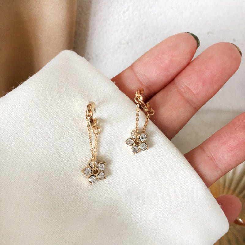 Gold hoop earrings with delicate flower charms and semi-precious stones for a feminine and elegant look.