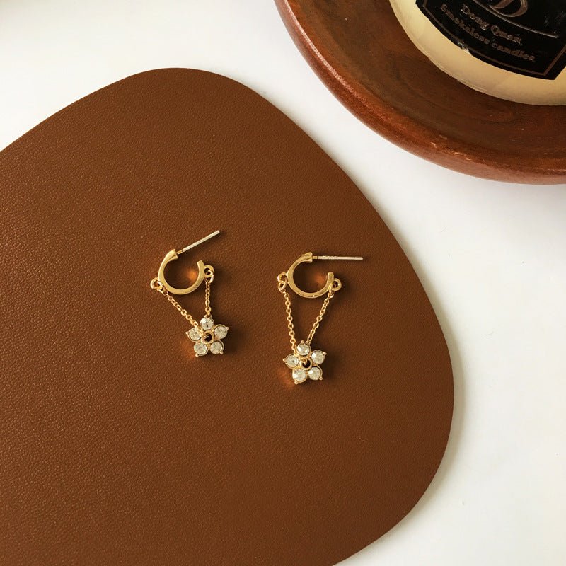 Gold hoop earrings with delicate flower charms and semi-precious stones for a feminine and elegant look.