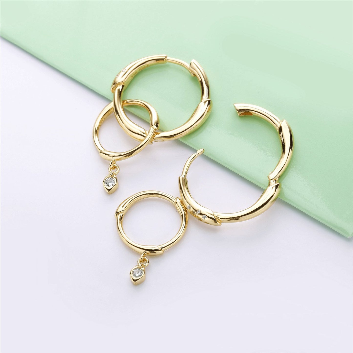 Gold hoop earrings with an interchangeable diamond charm for a versatile and stylish look.