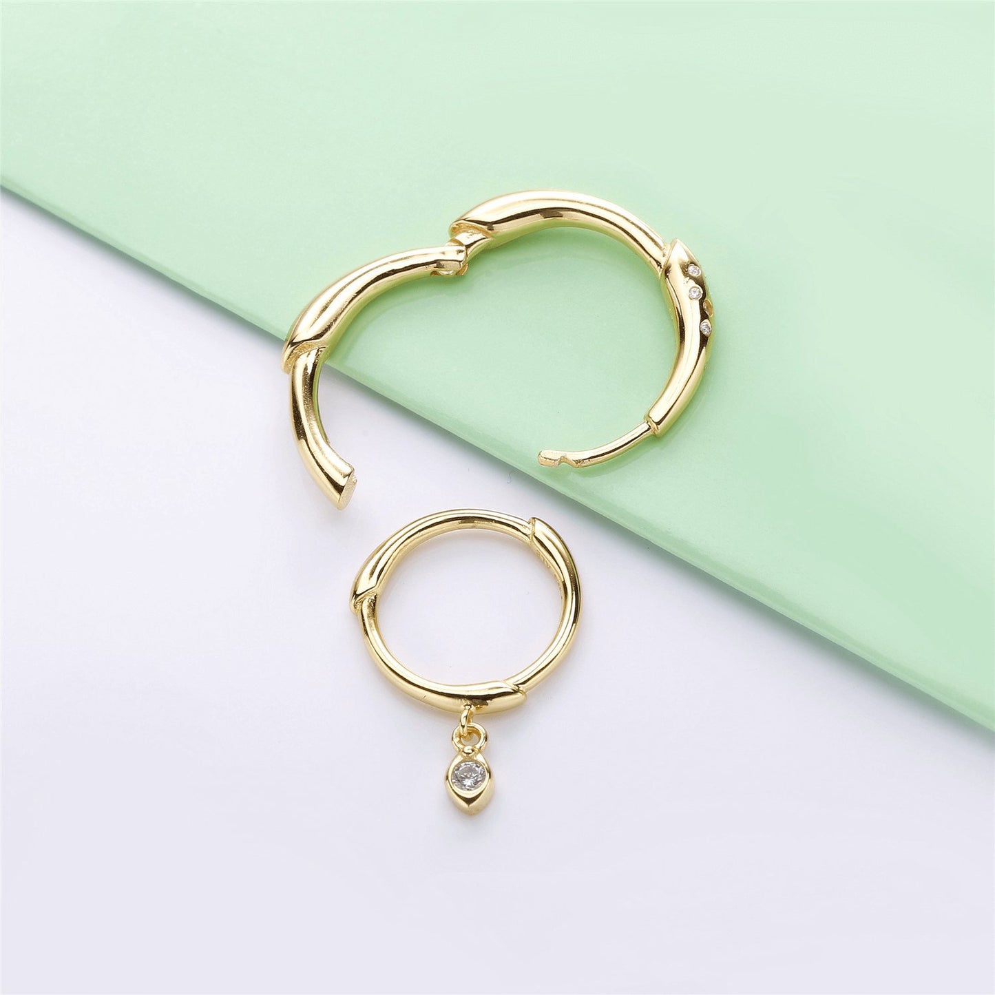 Gold hoop earrings with an interchangeable diamond charm for a versatile and stylish look.